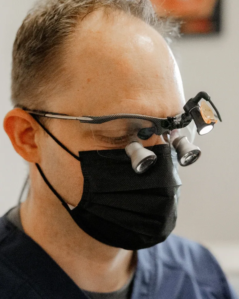 El Dr. Taylor Workman trabajando con lupas de aumento