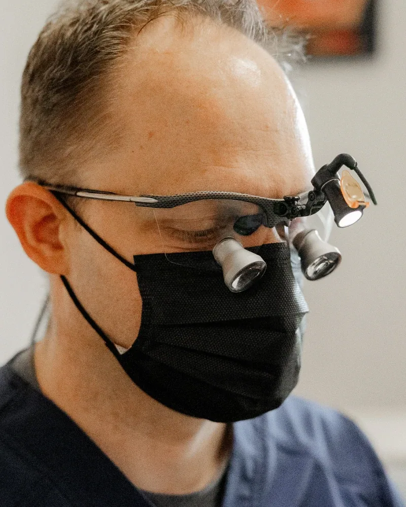 El Dr. Taylor Workman trabajando con lupas de aumento